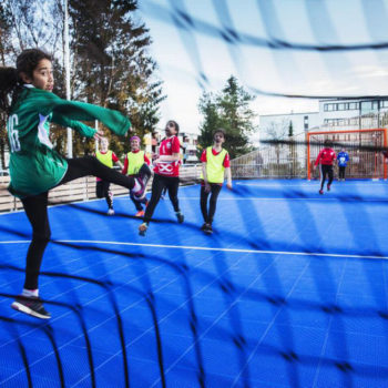Jenter ca. 11 år spiller handball. Keeperen snur seg etter ballen som treffer nettet.